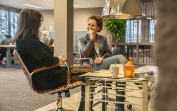 Professional office at Zaagmolenlaan 4, Woerden, with two people in a business discussion, modern furnishings, and natural light, ideal for office space rental.