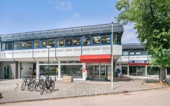 Exterior view of office building at Huis ter Heideweg 24, Zeist, showing multiple windows and a bike stand for office space rental.