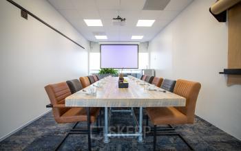Modern conference room with long wooden table and leather chairs located at Boerhaavelaan 40, Zoetermeer.