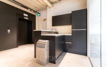 Modern office kitchenette with dark cabinetry at Boerhaavelaan 40, Zoetermeer, available for office space rental.