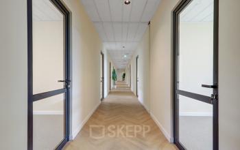 Bright hallway in office to rent at Edelgasstraat 101, Zoetermeer, showcasing modern doors and neutral walls.