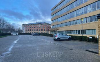 Exterior view of office building at Baron de Coubertinlaan 35 in Zoetermeer, featuring spacious parking area for office space rental.