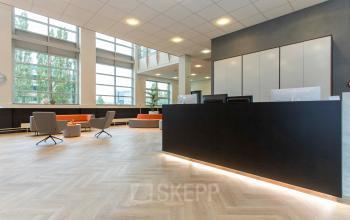 Spacious office reception area at Louis Braillelaan 80, Zoetermeer with modern decor, sleek seating, and large windows. Ideal spot for office space rental.