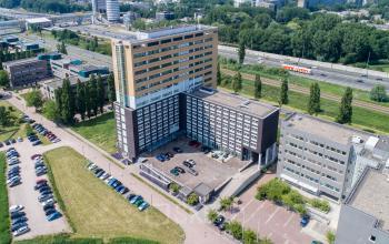 Aerial view of office building at Louis Braillelaan 80, Zoetermeer, showcasing ample parking and modern architecture for office space rental.