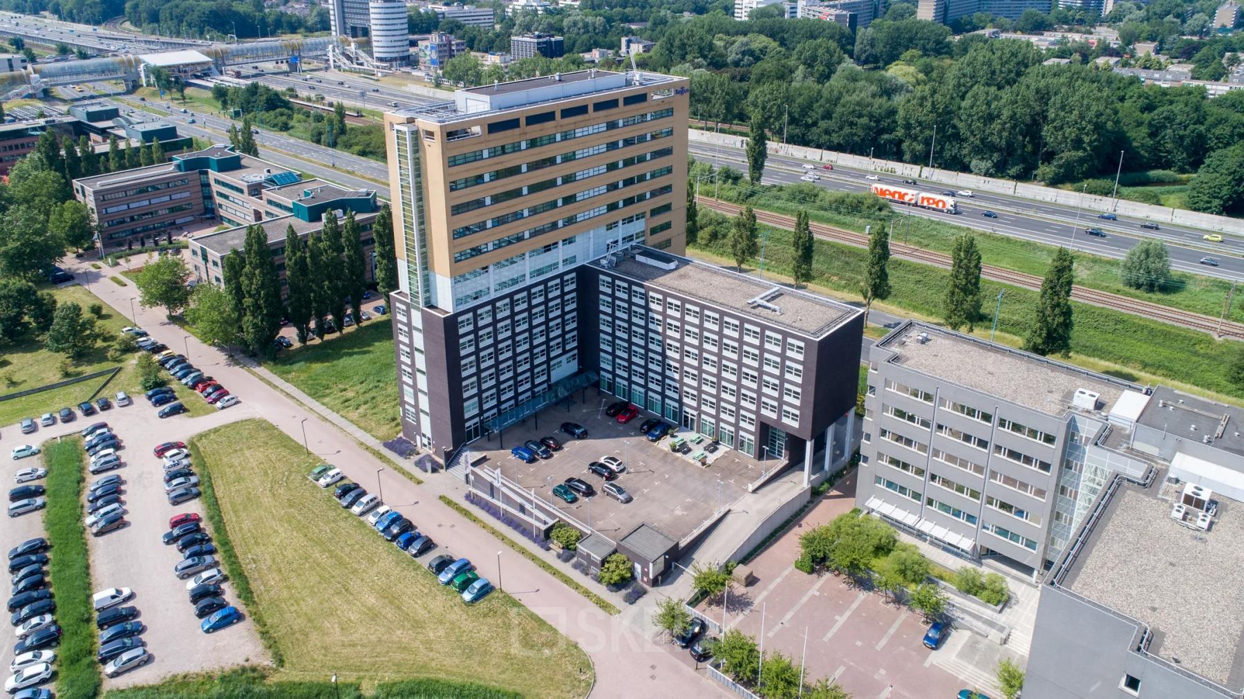 Aerial view of office building at Louis Braillelaan 80, Zoetermeer, showcasing ample parking and modern architecture for office space rental.