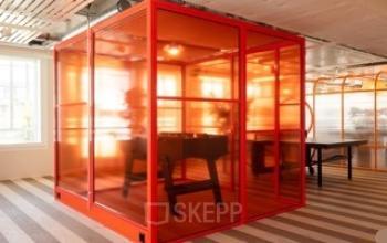 Modernes Büro mit rotem, verglasten Meetingraum und Tischfußball an der Stockerstrasse 33 in Zürich Enge.