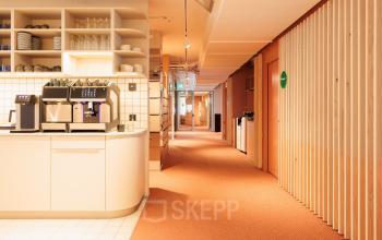 Gemütlicher Büroraum in der Stockerstrasse 33, Zürich Enge; möbliert mit Pantrybereich, perfekt für büro mieten. Heller Gang mit Regalen und Kaffeemaschine.