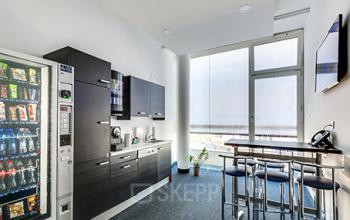 Modern pantry area in Zürich Old Town office space rental at Badenerstrasse 549, featuring vending machines, kitchenette, and high stools.