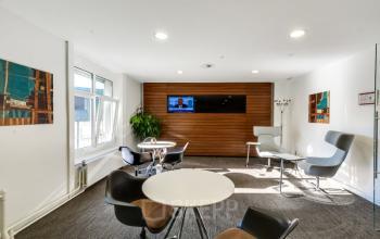 Modern office space rental at Bahnhofstrasse 100, Zürich Center, featuring stylish seating and a welcoming reception area with wooden accents.