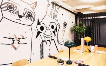 Modern gestalteter Büroraum mieten in Talacker 41, Zürich City, mit kreativer Wandgestaltung und Pflanzen, ideal für inspirierende Geschäftstreffen.