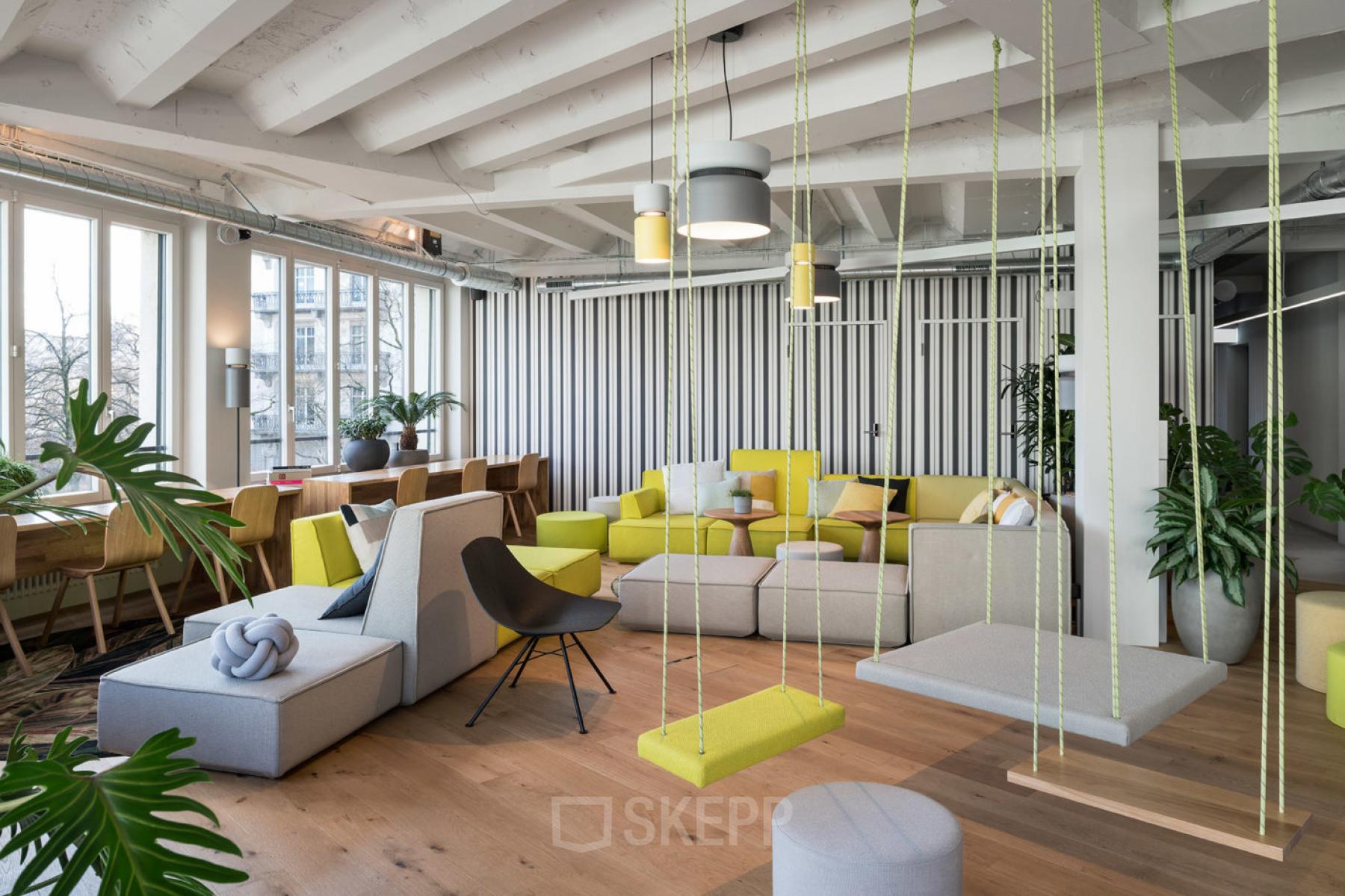 Modern gestalteter Lounge-Bereich im Büro in Talacker 41, Zürich City, mit bequemen Sitzmöglichkeiten und Pflanzen.