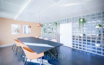 Moderner Besprechungsraum mit Glastrennwänden in der Löwenstrasse 29, Zürich City – ideal für Bürofläche mieten. Der Raum ist mit einem großen Tisch und stilvollen Stühlen ausgestattet.