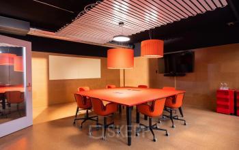 Moderner Konferenzraum mit rotem Tisch und Stühlen zur Miete im Bürogebäude Uraniastrasse 31, Zürich City.