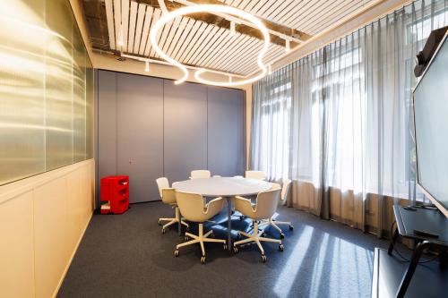 Modern conference room at Beethovenstrasse 48, Zürich Enge featuring stylish lighting, comfortable chairs, and a round table perfect for office space rental.