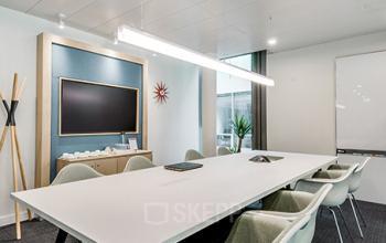 Contemporary conference room for office space rental at Richtistrasse 7, Zürich East, with a long table, chairs, and a presentation screen.