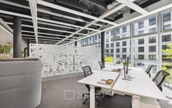 Moderne und helle Bürofläche in Zürich Seebach mit großen Fenstern und ergonomischen Arbeitsplätzen. Vereinzelte Pflanzen sorgen für eine angenehme Atmosphäre. Perfekt für Unternehmen, die Büroraum mieten möchten.