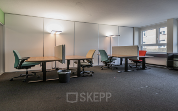 Well-lit office space rental at Dufourstrasse 43, Zürich Seefeld, featuring modern desks with ergonomic chairs and large windows.