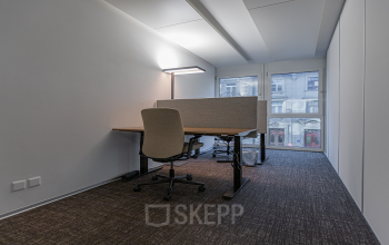 Modern office space rental at Dufourstrasse 43, Zürich Seefeld, with a well-lit desk area and comfortable chair facing a window.