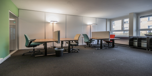 Well-lit office space rental at Dufourstrasse 43, Zürich Seefeld, featuring modern desks with ergonomic chairs and large windows.