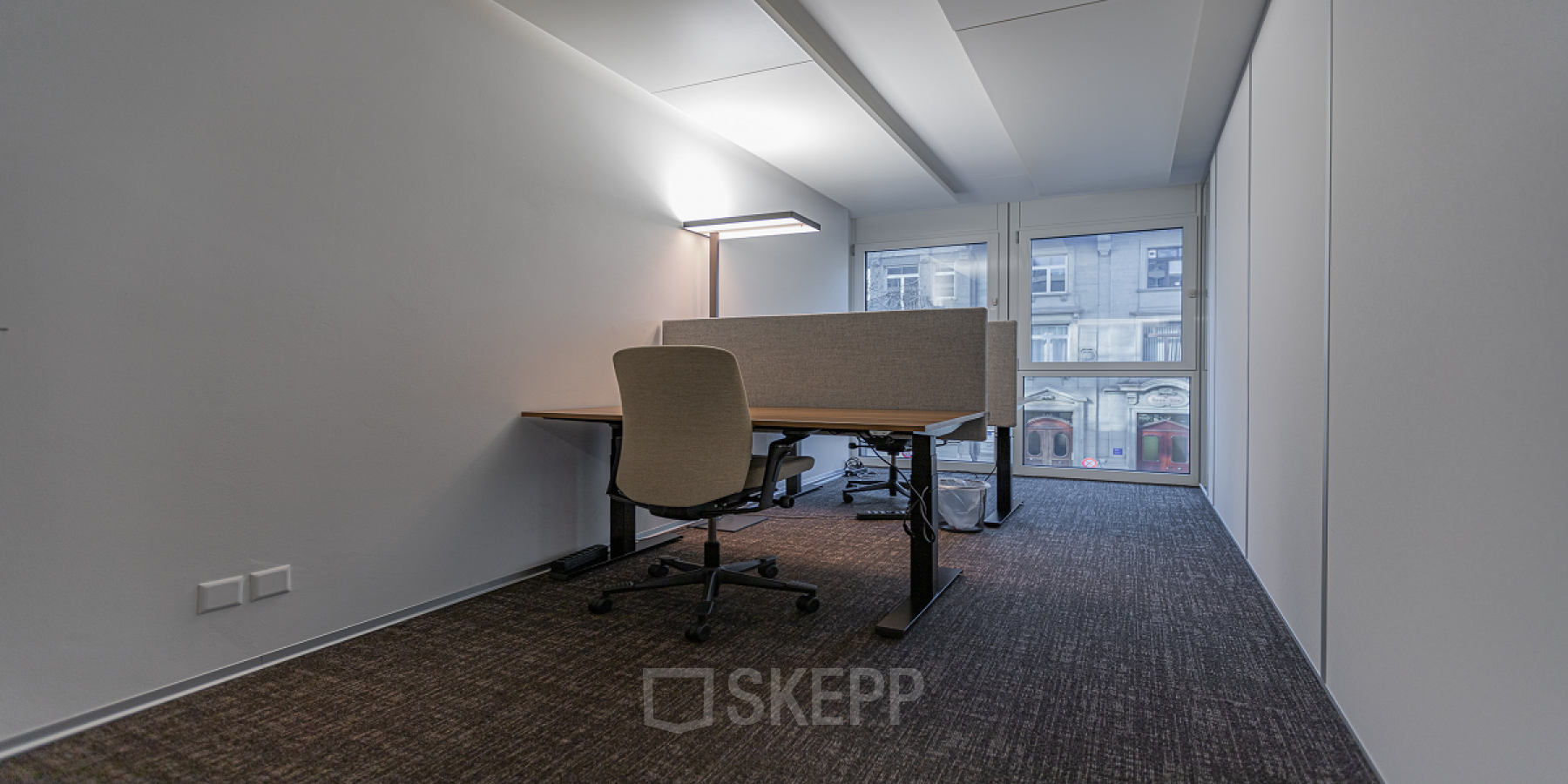 Modern office space rental at Dufourstrasse 43, Zürich Seefeld, with a well-lit desk area and comfortable chair facing a window.