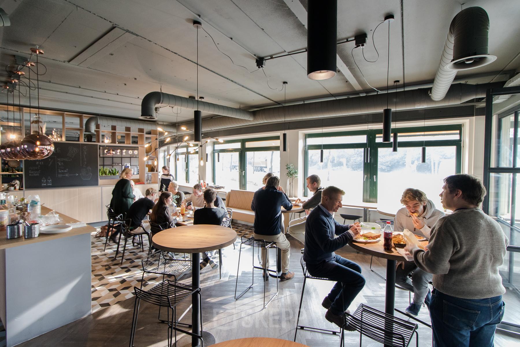 Modern and welcoming office space rental at Hanzelaan 351-361, near Zwolle Centraal Station, with people engaged in casual business lunches.