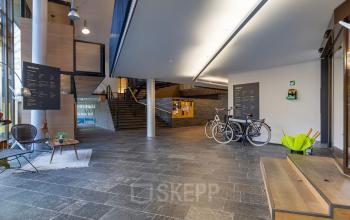 Spacious entrance area at Assendorperdijk 1, Zwolle, ideal for office space rental, featuring a sleek modern design with bicycles parked nearby.