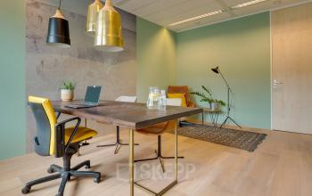 Furnished office space in Zwolle at Assendorperdijk 1, featuring a table with chairs, laptop, and stylish lighting for a professional atmosphere. Ideal for office space rental.