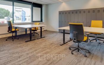 Bright office space at Assendorperdijk 1 in Zwolle, featuring large windows, modern desks with yellow chairs, and lockers, ideal for office space rental.