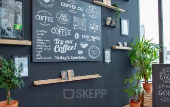 Interior of an office space at Assendorperdijk 1, Zwolle, featuring a black wall with coffee-themed decor and potted plants, suitable for office space rental.