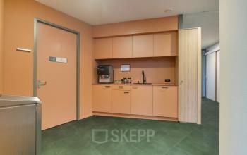 Office pantry space at Zwartewaterallee 56, Zwolle featuring sleek cabinets and a modern coffee machine, ideal for office space rental with easy access to amenities.