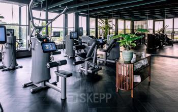 A modern, furnished gym area with exercise equipment at Ceintuurbaan 28, Zwolle. Ideal for those seeking an office space rental with fitness amenities.