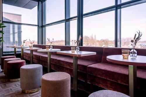 Bright and cozy furnished office space in Zwolle at Ceintuurbaan 28, featuring modern tables and seating with a view. Ideal for those seeking an office to rent.