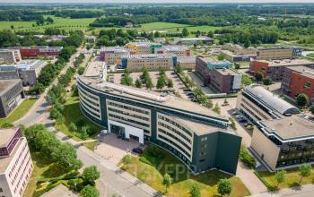 Aerial view of a modern office building at Dokter van Deenweg 1, Zwolle, ideal for office space rental, surrounded by greenery and other commercial buildings.