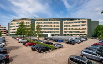 Exterior view of the office building located at Dokter van Deenweg 1 in Zwolle, featuring ample parking space available for office space rental.