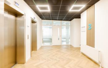 Bright and modern reception area in Zwolle's office building on Zuiderzeelaan 15-25, featuring sleek elevator doors and contemporary design, ideal for office space rental.