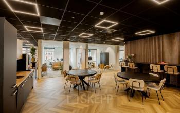 Modern office space available for rent at Zuiderzeelaan 15-25, Zwolle, featuring round tables and chairs under stylish lighting.