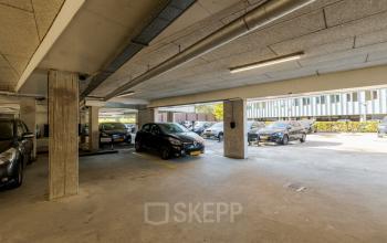 Covered parking area at Zuiderzeelaan 15-25 in Zwolle, featuring multiple parked cars under a concrete ceiling, ideal for tenants seeking office space rental with convenient parking.