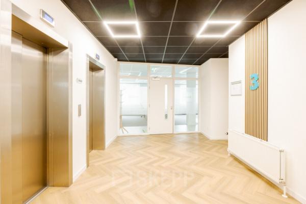 Bright and modern reception area in Zwolle's office building on Zuiderzeelaan 15-25, featuring sleek elevator doors and contemporary design, ideal for office space rental.